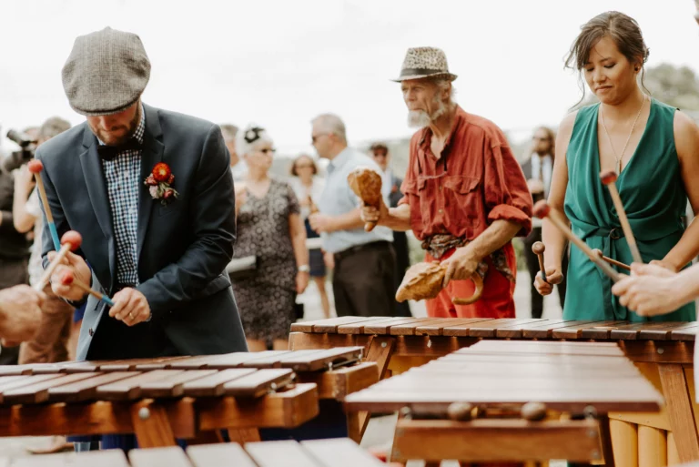 bride and groom playing instruments in a band at the wedding in new zealand